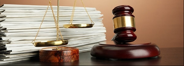 Golden scales of justice, gavel and folders on brown background